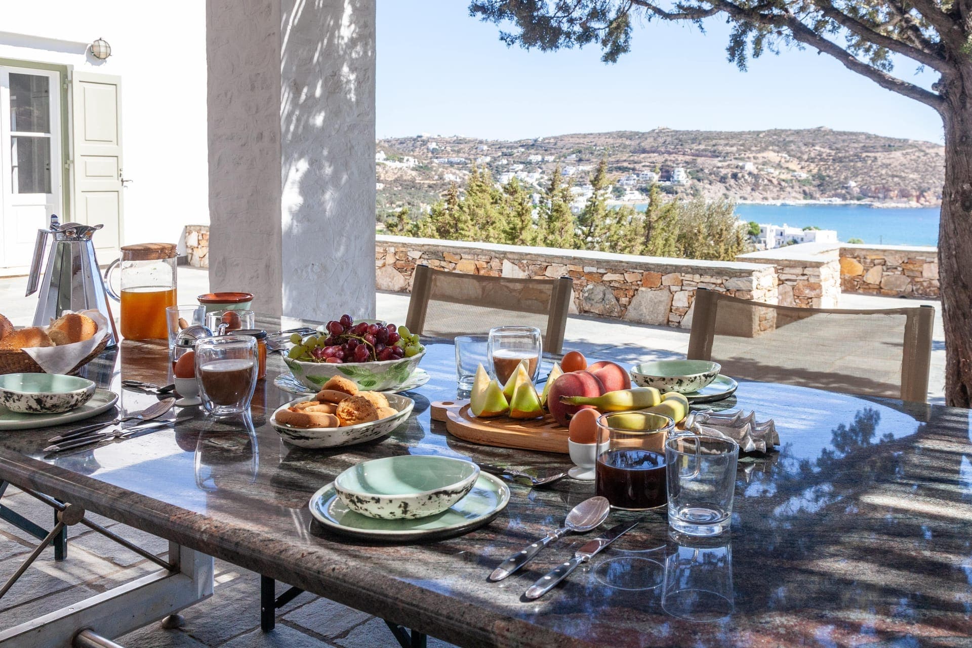 Breakfast laid out on the terrace table at Villa Olivia Clara, overlooking Platis Gialos bay
